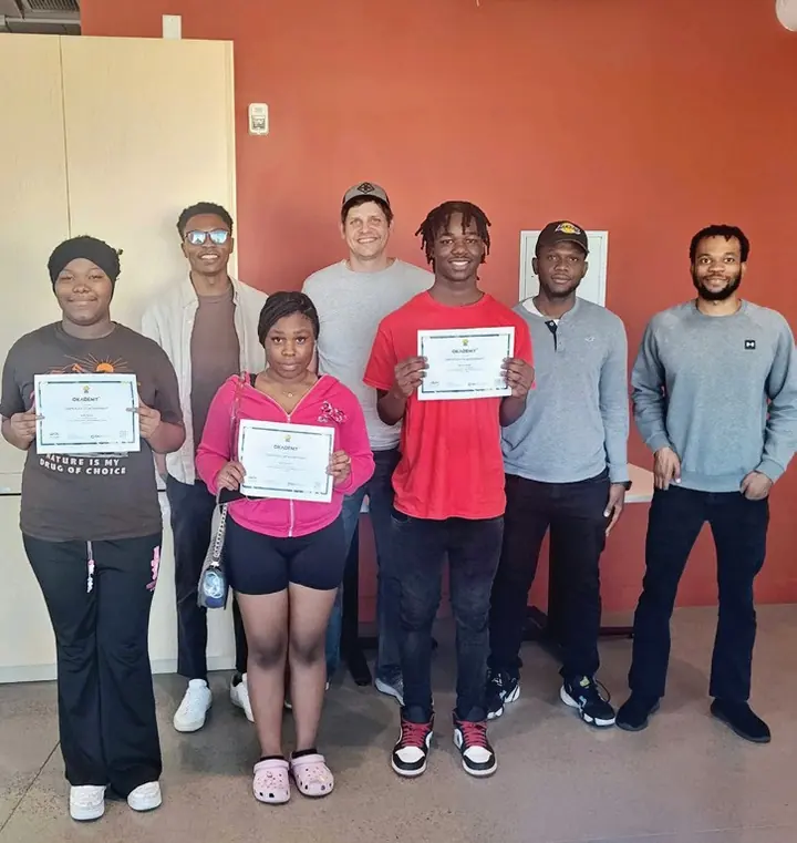 Okademy graduates holding their certificates