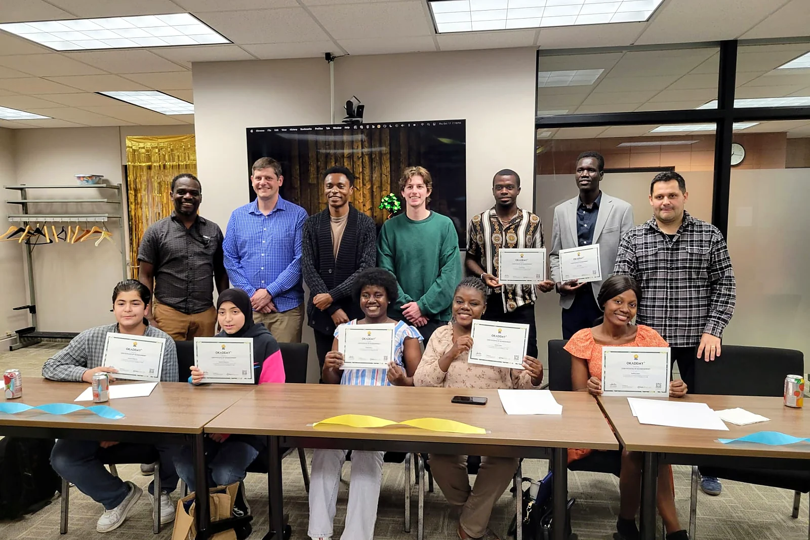 A full cohort of Okademy learners with their certificates of achievement