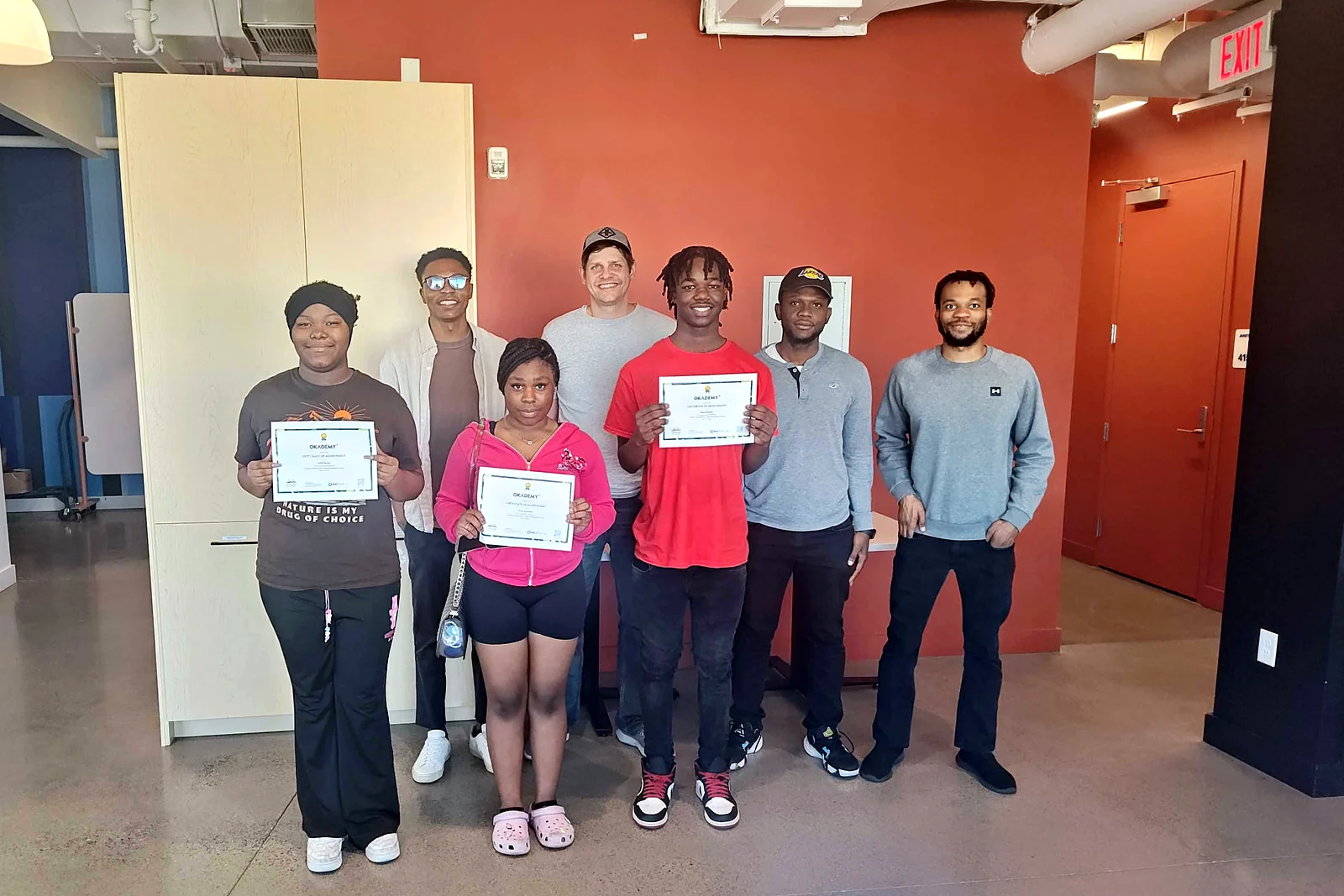 Okademy graduates celebrating with their certificates after a cohort