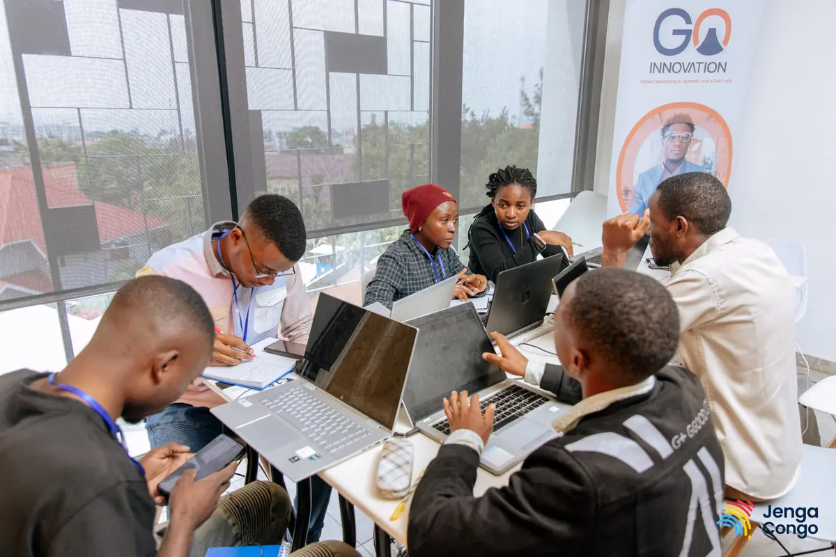 A hackathon team working together on laptops